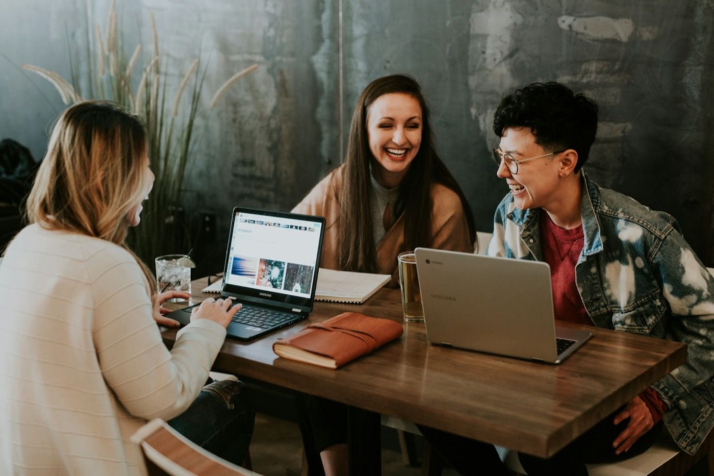 Drie collega's lachen samen aan tafel